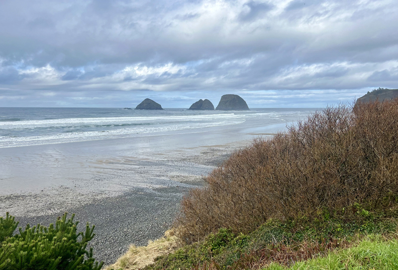 3 Arch Rocks in Oceanside, OR on a partly cloudy day.