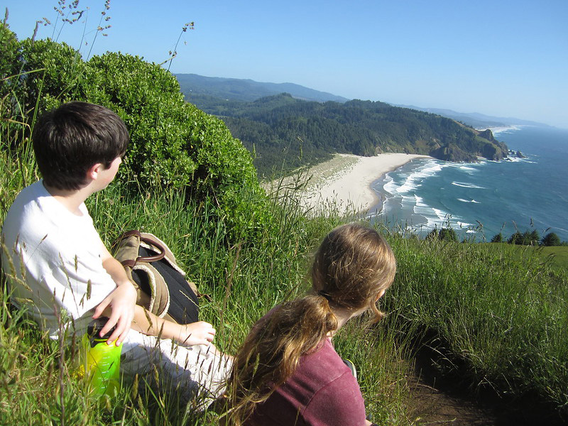Kids sitting and enjoying the beautiful ocean views from the Cascade Head Trail.