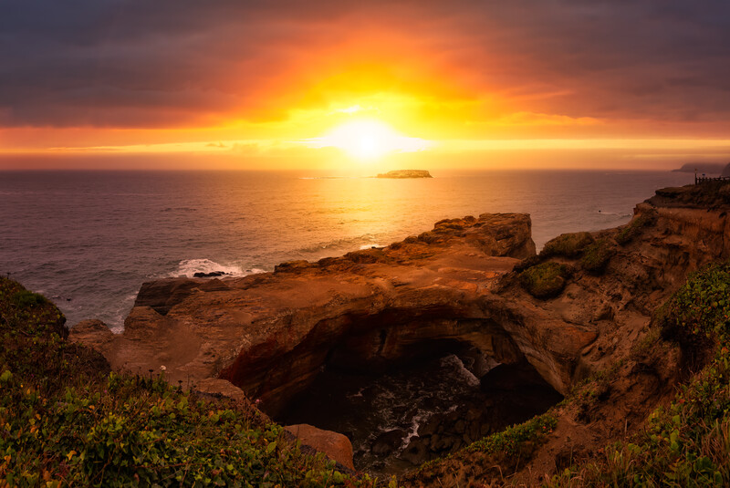 Sunset over Devils Punchbowl State Park during with a calm ocean surf.